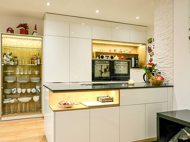 Moderne Küche mit Kochinsel und Naturstein-Arbeitsplatte und die E-Geräte in der richtigen Arbeitshöhe.