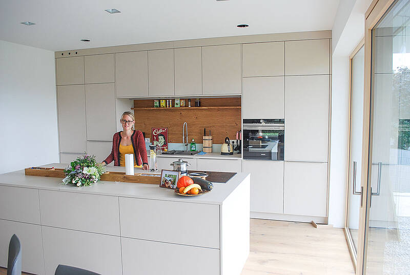 Wandverbau mit integrierter Küchenzeile und Kochinsel mit dem BORA- Abluftsystem.