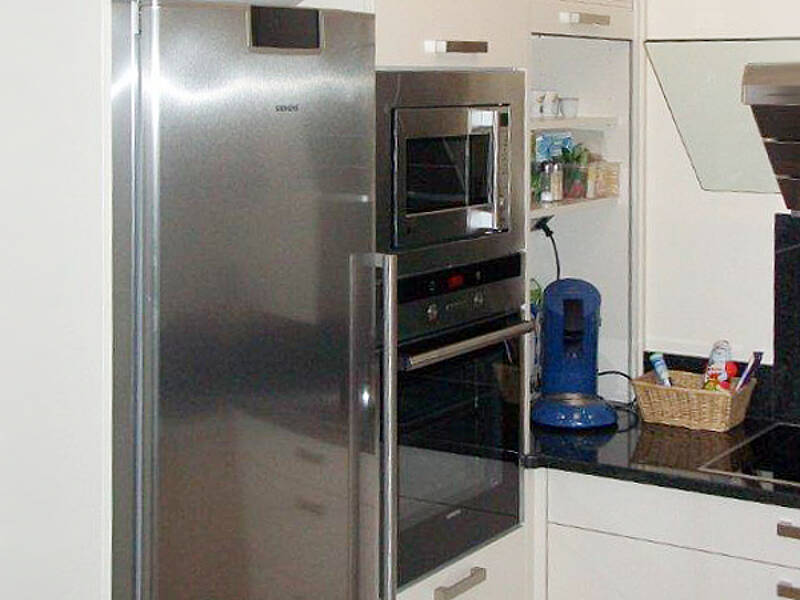 U-Küche mit Naturstein Arbeitsplatte und kleiner integrierter Anrichte.