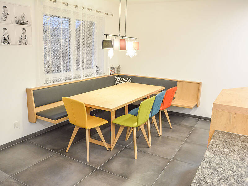 Moderne U-Küchen in Holz-Optik und mit Naturstein-Arbeitsplatte.