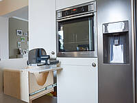 U-Küche mit Küchenzeile und Naturstein-Arbeitsplatte, das Augenmerk gilt aber den Fronten im Landhaus-Stil.
