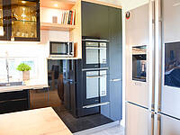 Küche in U-Form mit integrierter Kochinsel und freistehenden Kühlschrank.