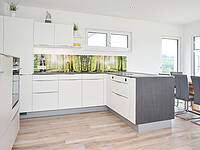 L-Küche mit getrennter Gerätefront, bedruckter Glasrückwand und einer Essplatz-Lösung.