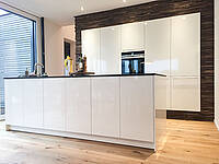 In die Wand integrierte Küchenzeile mit Altholz-Umrandung und Kochinsel mit BORA-Abluftsystem.