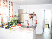 U-Küche in weiß mit freistehenden Kühlschrank.