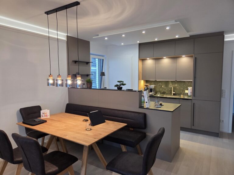 Küche mit matt grauer front und Arbeitsplatte in schwarz, Esszimmer mit Massivholztisch in Eiche