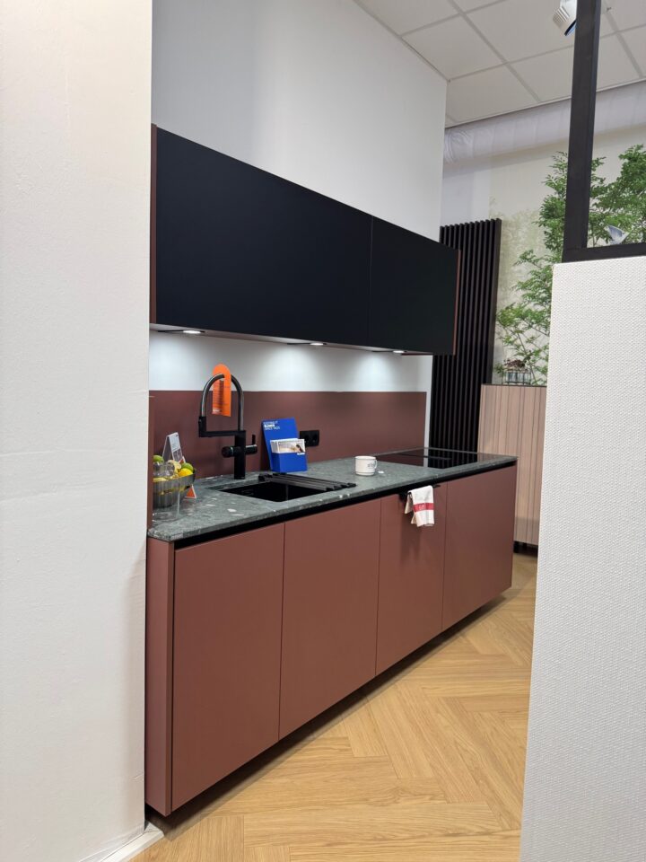 Küche in weinrot und schwarz mit Natursteinarbeitsplatte in Moosbachgrün