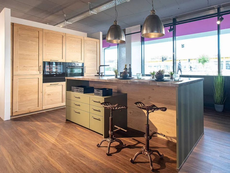 Landhasuküche in Holz natur mit Insel in grün und dunkler Arbeitsplatte