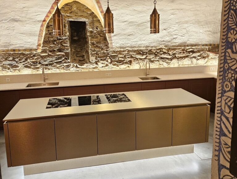 Küche mit Front in gold und heller Mineralstoffarbeitsplatte