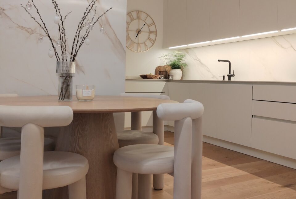Elegante Küche in weiß mit rundem Tisch in Eiche