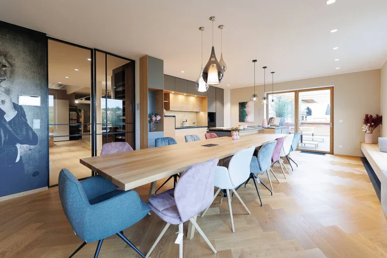 Kochen-Wohnen Kombination mit langem Tisch und Küche in grau matt und Naturfronten kombiniert