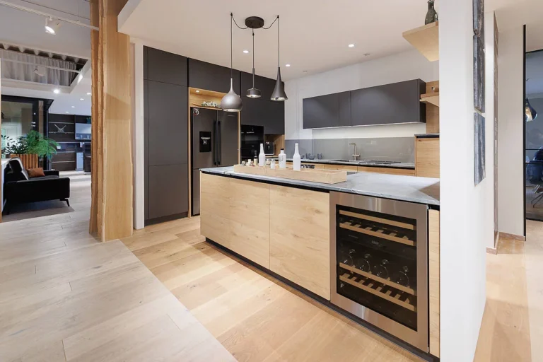 L-Küche mit Insel in schwarz matt und Eiche hell kombiniert. Weinkühlschrank in der Insel verbaut