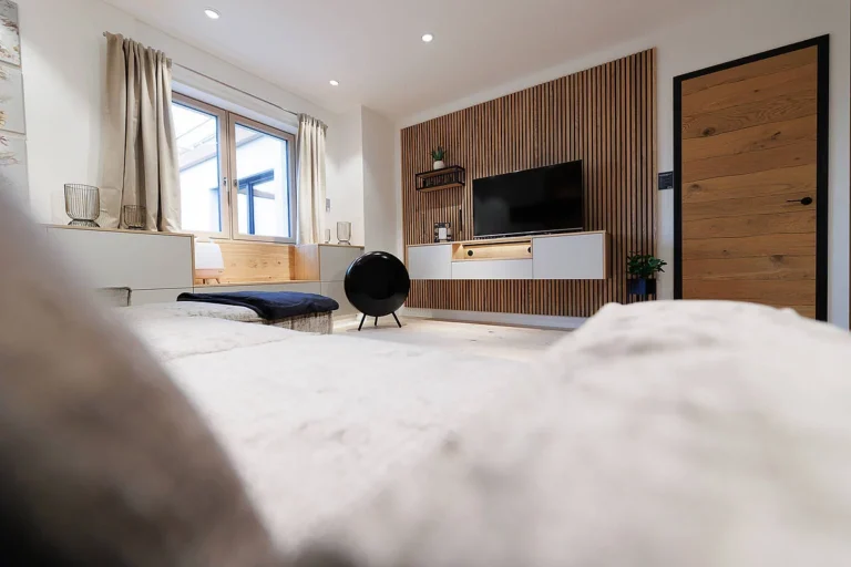 Wohnzimmerverbau mit Natruholzlamellen und weißen Sideboards